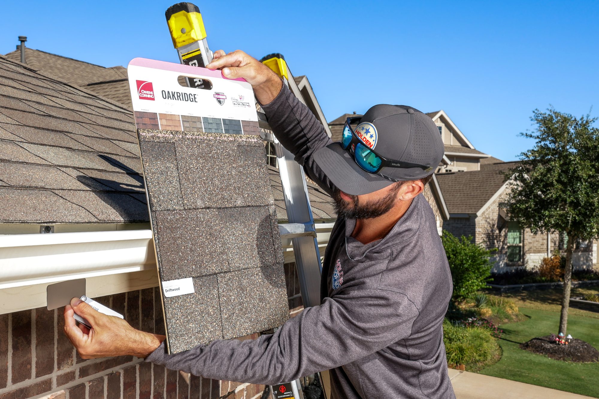 roofing contractor Elgin TX, Holden Roofing Austin project manager photographing hail dents on R-panel at a shop on Old McDade Road, roof repair, roof replacement and storm damage roof repair serving Elgin, Bastrop, Manor and Taylor
