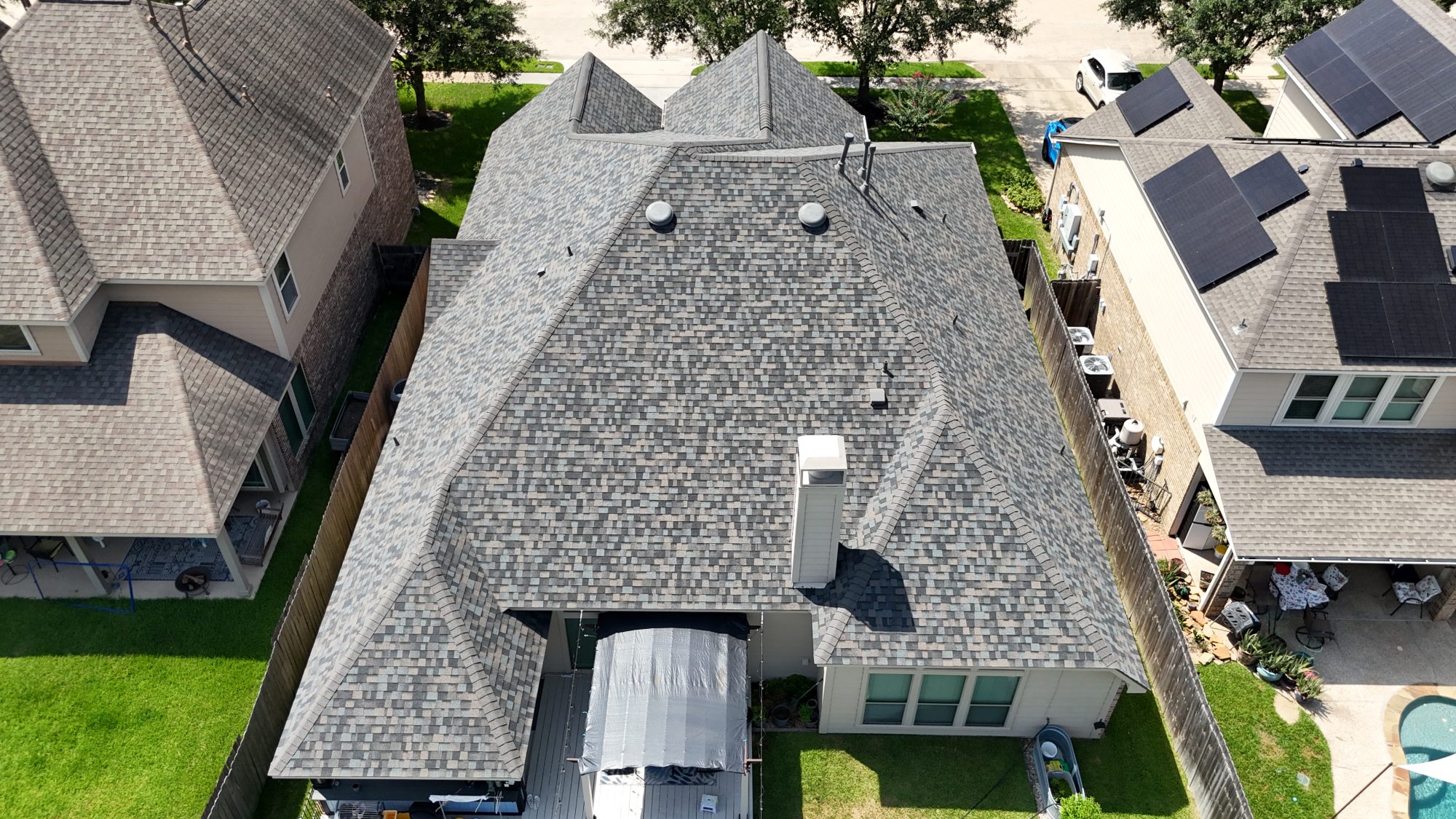 Shingle roof in a subdivision with solar-equipped neighbors, aerial
