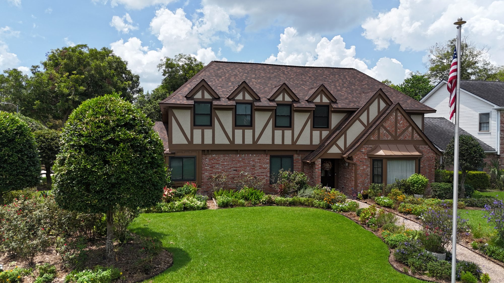 Tudor-style home with a new shingle roof, street view
