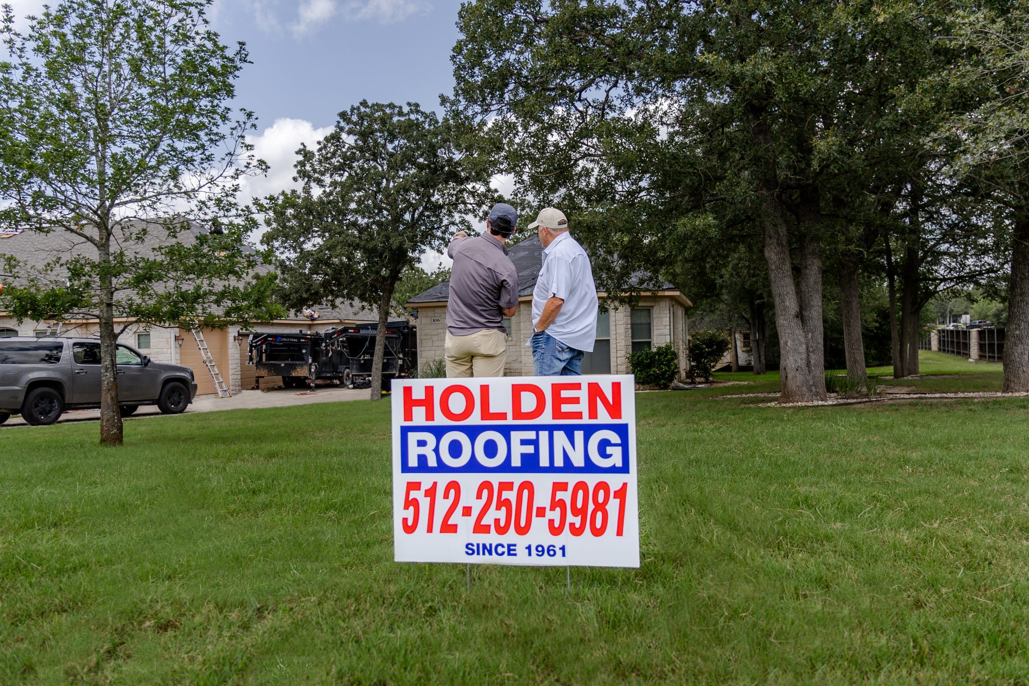 A Holden Roofing yard sign in front of a job in progress