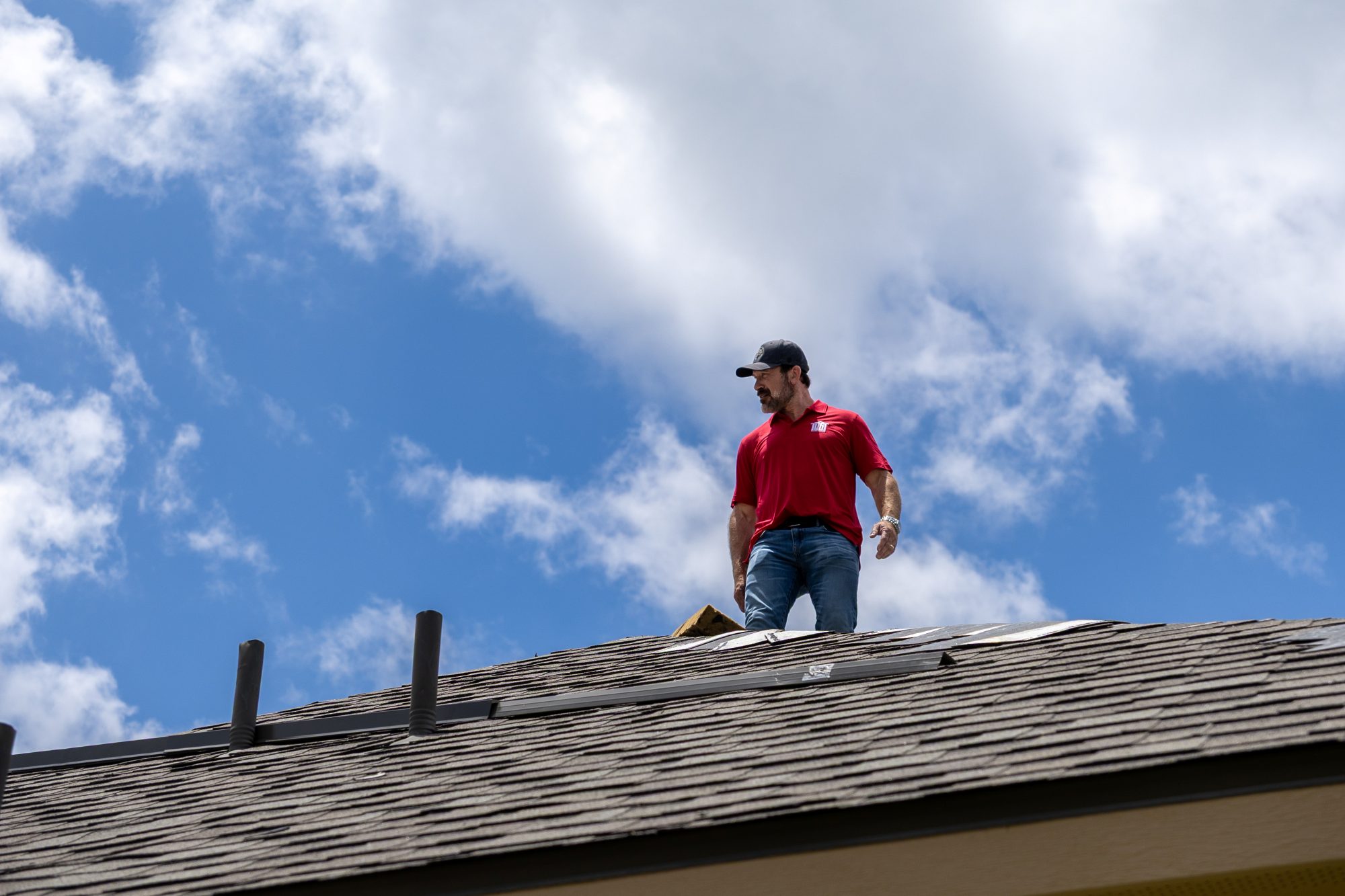 A Holden roofer on a shingle roof during install