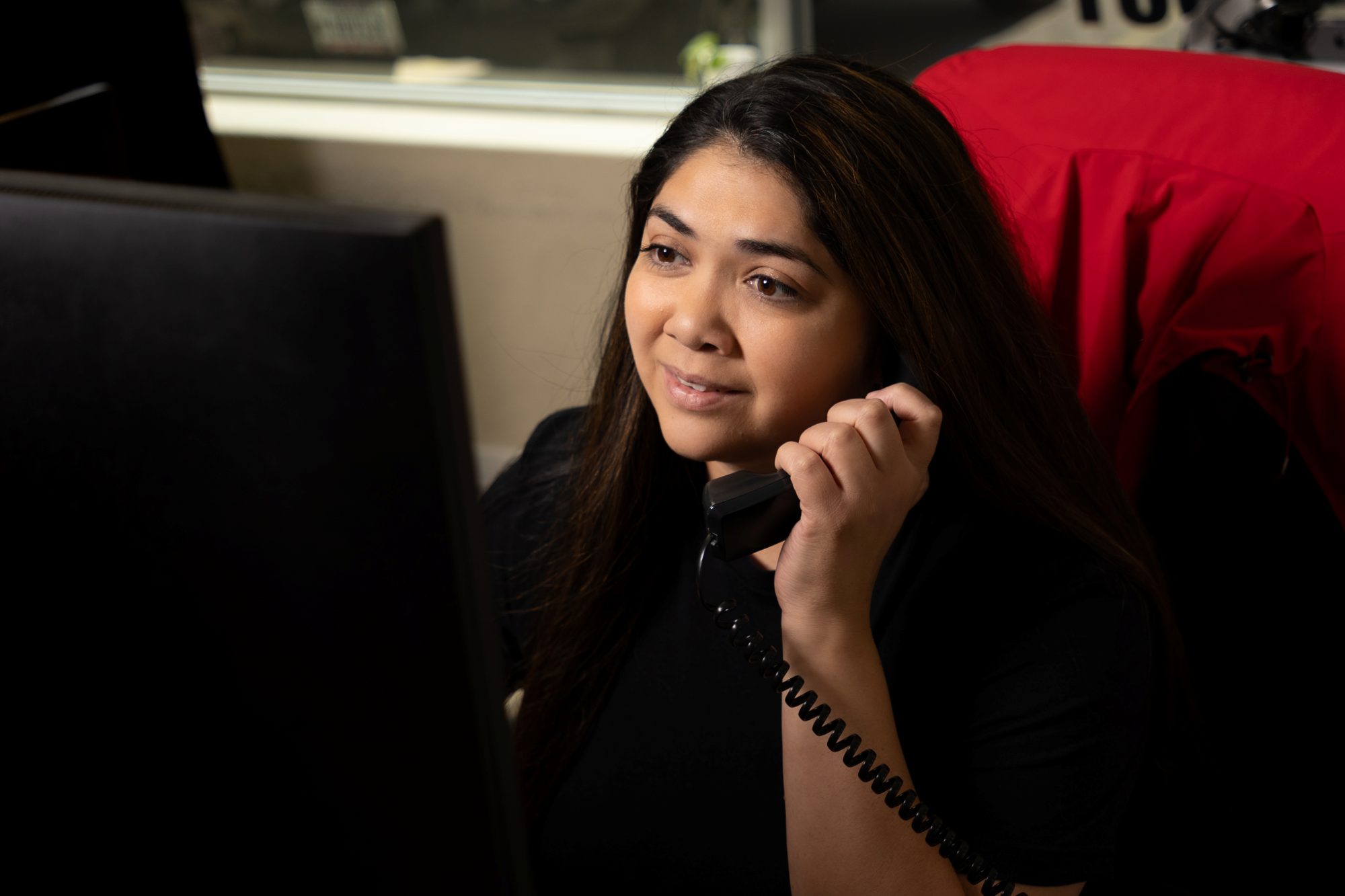 A Holden Roofing coordinator on the phone with a homeowner