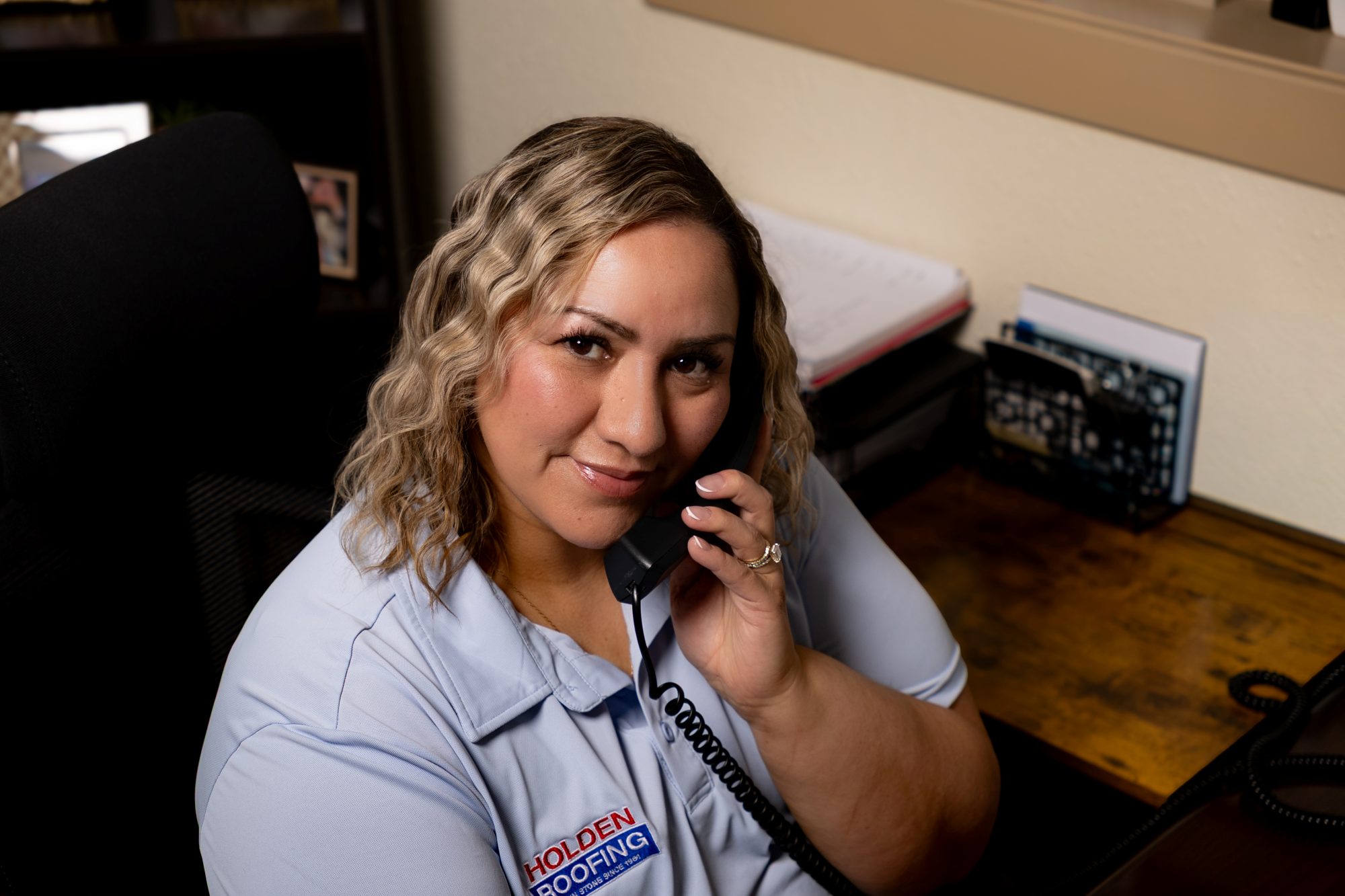 A Holden Roofing office manager taking a call
