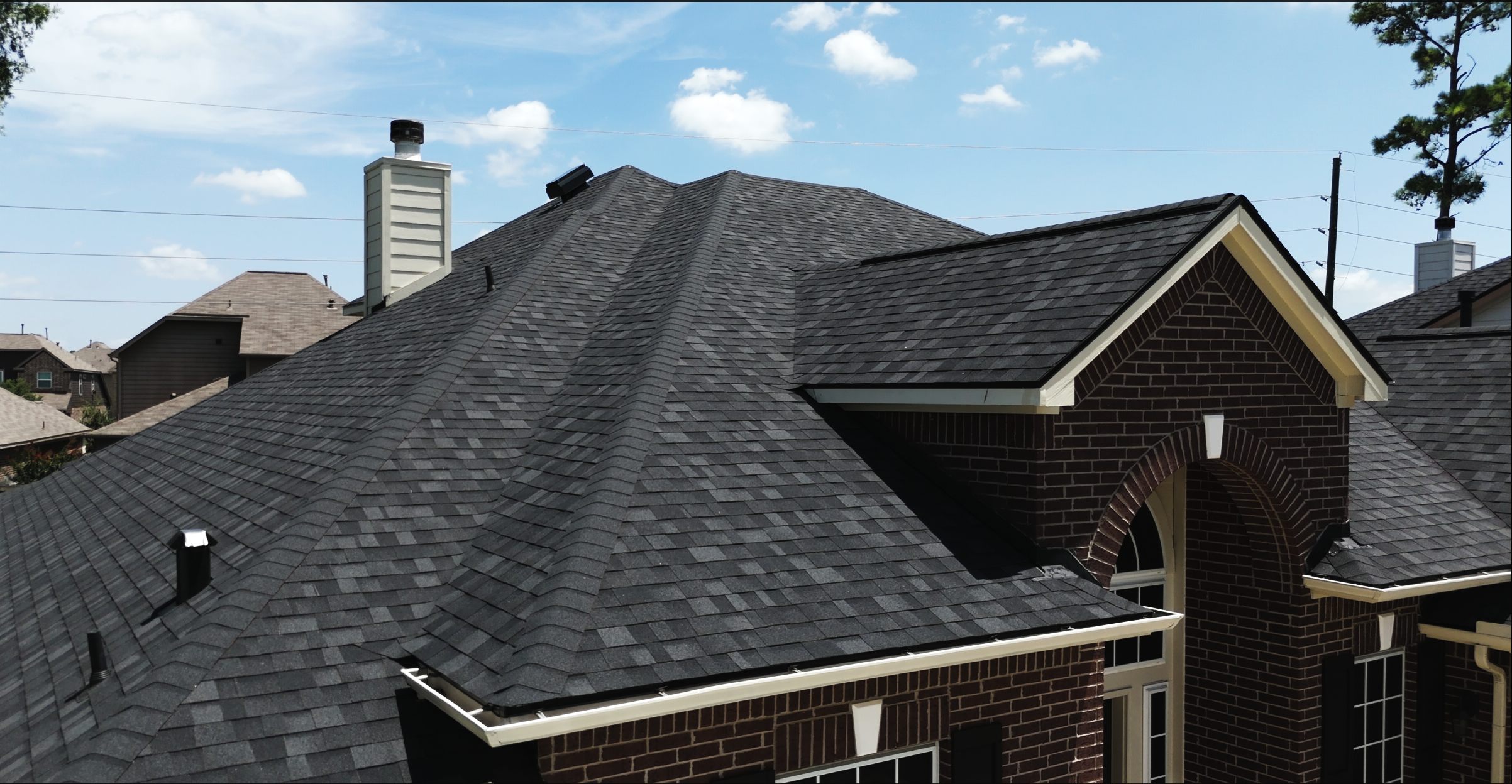 Black architectural shingle roof on a brick home