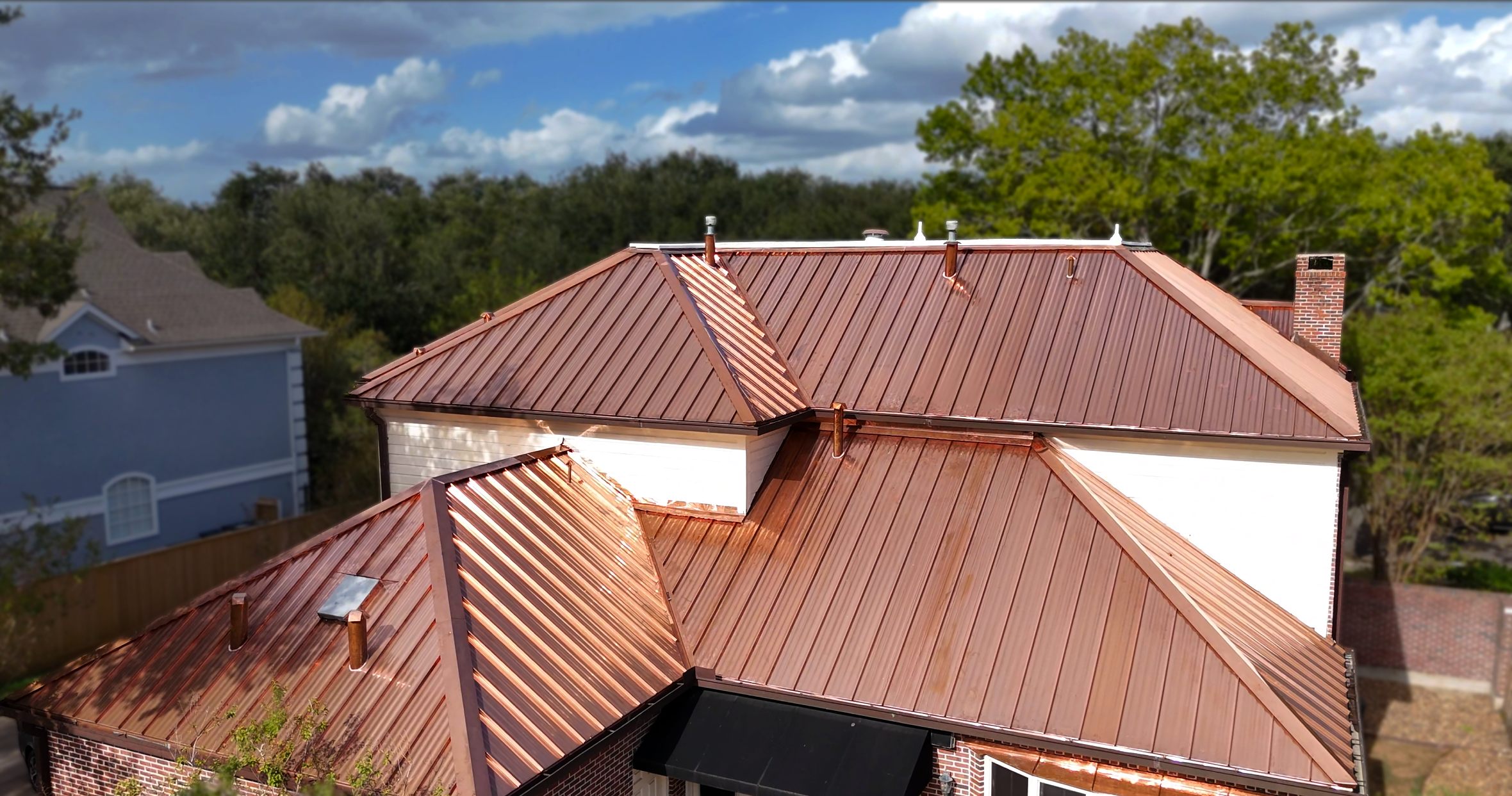 Copper standing seam metal roof on a brick home
