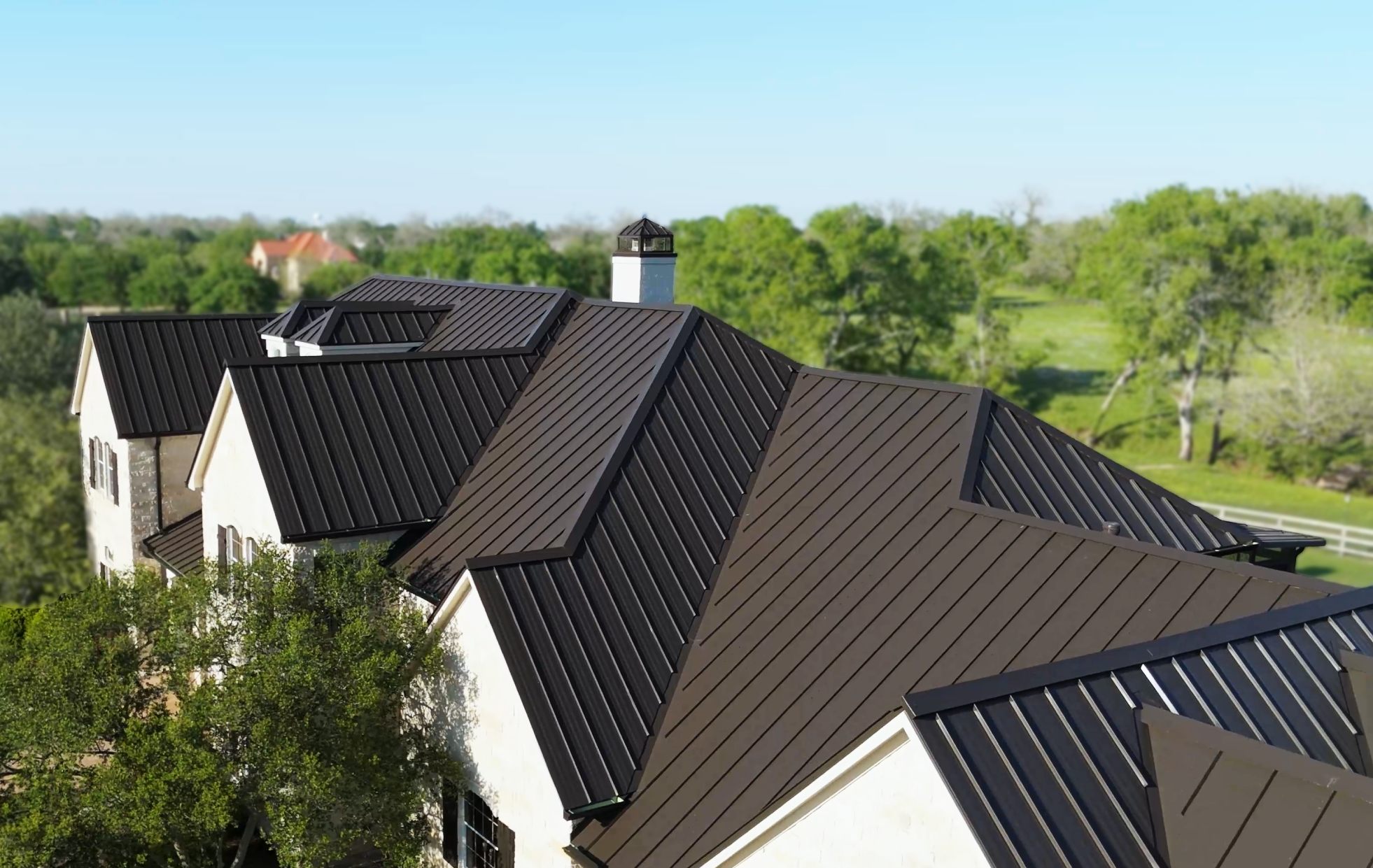 Dark standing seam metal roof on a two-story home