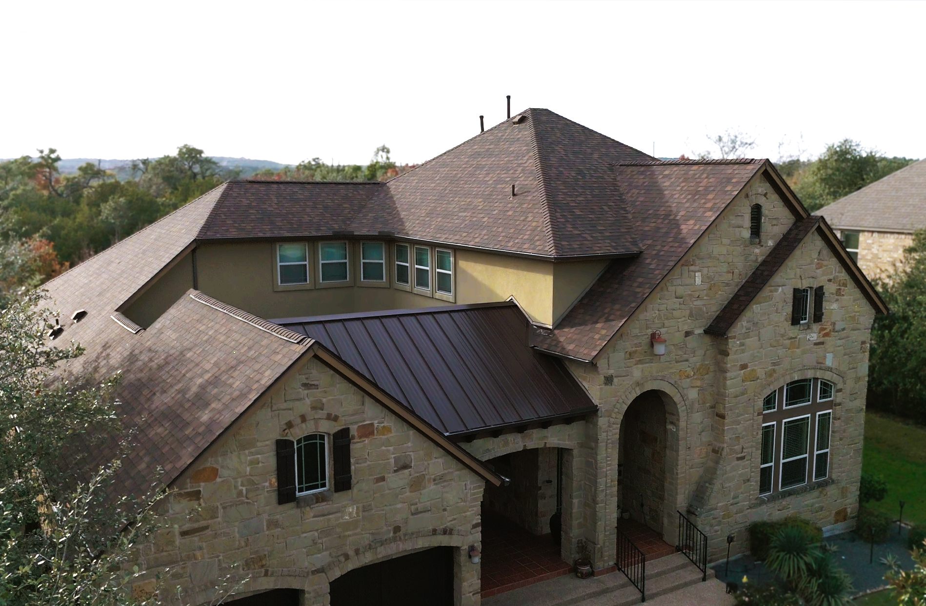Stone home with tile roof and metal porch roof